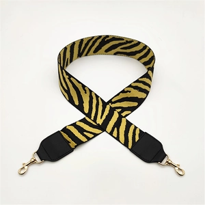 Close-up of zebra stripe wide bag strap with golden metal swivel hooks and black leather ends