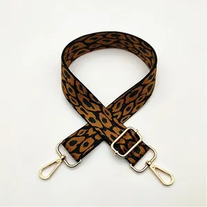Detailed view of leopard print bag strap with golden metal hooks and adjustable buckle