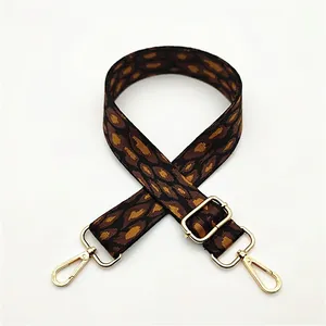 Detail of adjustable polyester leopard print bag strap with polished gold metal hardware