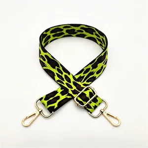 Detail of green leopard print bag strap with golden lobster clasp and adjustable buckle