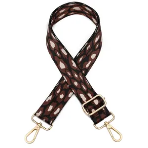 Close-up of leopard print polyester bag strap with golden metal swivel hooks and buckle