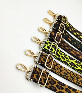 Detail of adjustable leopard print bag straps with high-gloss gold-plated metal hooks