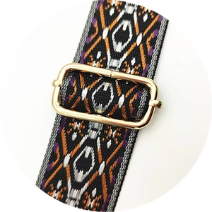 Gros plan sur une bandoulière ethnique tissée avec boucle de réglage en métal doré