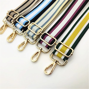 Detailed macro view of colorful striped woven bag straps with golden metal hooks