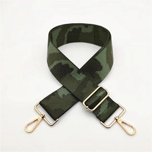 Detail of wide adjustable green camouflage bag strap with light gold metal lobster clasps