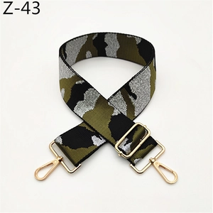 Detail of adjustable camouflage bag strap with gold metal hooks and durable webbing