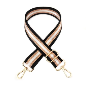 Detail view of woven bag strap with rose gold glitter threads and gold metal buckle