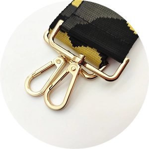 Close-up of leopard print nylon bag strap with polished gold-tone lobster claw clasps