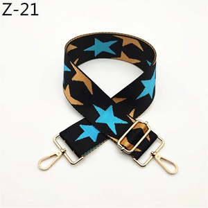 Detail of adjustable star pattern wide bag strap with shiny gold metal lobster clasps