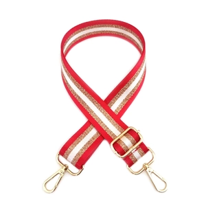 Detail of adjustable woven purse strap with red white and gold metallic stripes