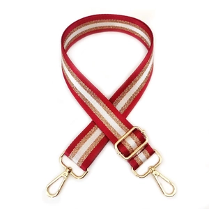 Detail of red, white and gold striped adjustable purse strap with golden metal lobster hooks