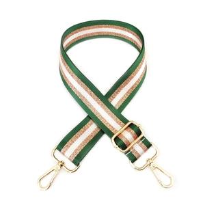 Detail view of striped nylon bag strap with green and gold glitter threads and gold hardware