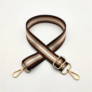 Close-up of brown and gold stripe replacement bag strap with adjustable metal buckle