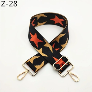 Detail of adjustable star pattern bag strap with gold metal hooks and pop art design