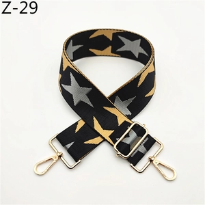 Detail of adjustable nylon bag strap with gold and silver stars on black weave