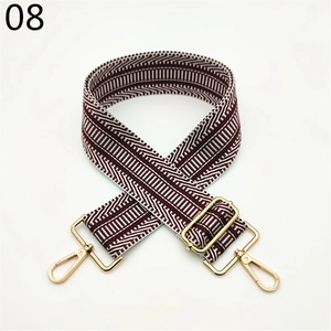 Detail of burgundy and white woven bag strap with golden metal swivel hooks