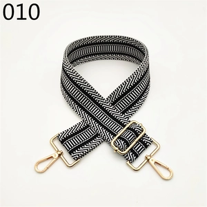 Macro detail of widened black and white geometric woven strap with golden metal buckle