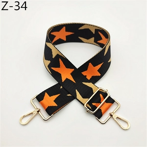 Detail of colorful star woven wide bag strap with gold metal swivel hooks and buckles