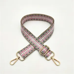Close-up of pink and grey geometric woven shoulder strap with gold metal lobster clasps