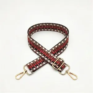 Detail of geometric woven bag strap with thick texture and gold metal lobster clasps