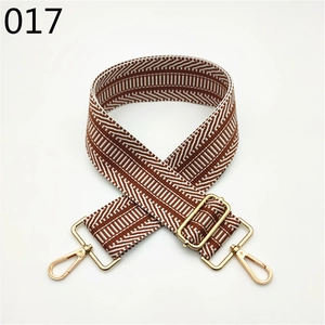 Detail of adjustable wide bag strap with brown and white chevron pattern and gold hooks
