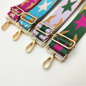 Detailed view of woven star-patterned wide straps with gold metal lobster clasps