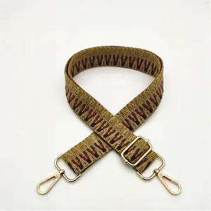 Detailed close-up of ethnic geometric woven bag strap with gold metal lobster clasps