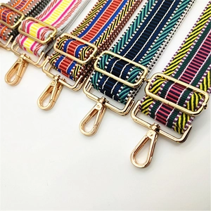 Detail of colorful geometric woven bag straps with adjustable light gold metal hooks