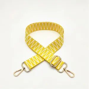 Detail of yellow and white woven replacement shoulder strap with gold metal swivel hooks