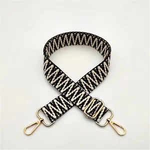 Close-up of black and white zigzag woven strap with premium gold metal hardware hooks