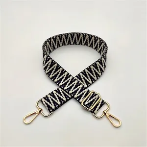 Detail of black and white geometric woven replacement strap with gold metal hooks