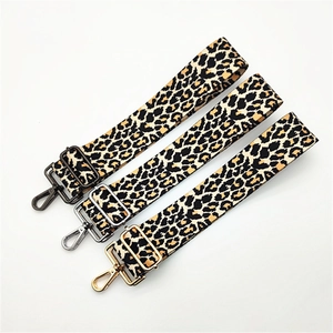 Detailed view of leopard print bag straps with black, silver, and gold metal hardware