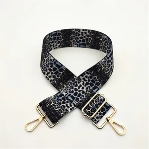 Detail of blue leopard print wide bag strap with glossy gold metal swivel hooks