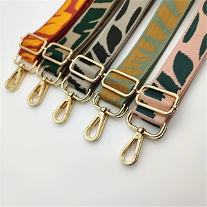Détail de cinq bandoulières de sac réglables en jacquard à motifs feuilles et boucles dorées