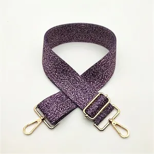 Close-up of adjustable purple floral woven bag strap with golden metal lobster clasps