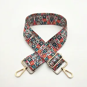 Detail of adjustable woven replacement bag strap with zebra and floral pattern and gold hooks