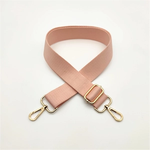 Detail of adjustable pink nylon handbag strap with polished gold lobster clasps
