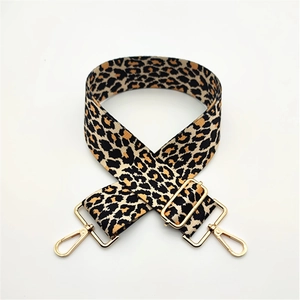 Detail of adjustable leopard print bag strap with golden metal swivel hooks and buckles