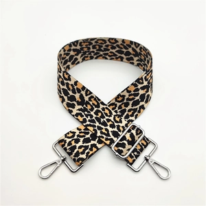 Detailed view of leopard print wide bag strap with silver metal swivel hooks and buckle