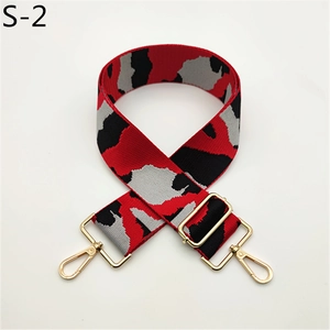Close-up of wide camo handbag strap with red pattern and gold metal buckles