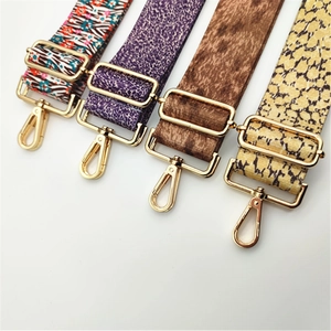Detail view of four patterned bag straps with golden metal hooks and adjustable buckles