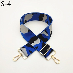Detail of wide camo woven bag strap with golden metal swivel hooks and adjuster