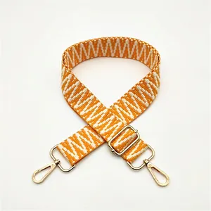 Vue détaillée de la bandoulière tissée avec motif orange et attaches en métal doré