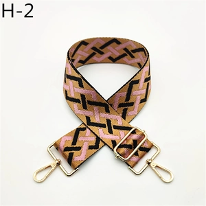Detail of adjustable canvas bag strap with geometric weave and gold metal swivel hooks