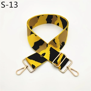 Close-up of a wide adjustable camouflage shoulder strap with golden metal swivel hooks