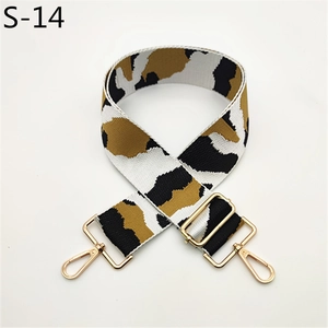 Detail of adjustable wide camouflage strap with leopard pattern and gold metal hooks