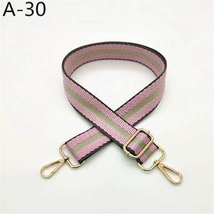 Détail de la sangle rayée rose et grise avec boucles métalliques dorées réglables