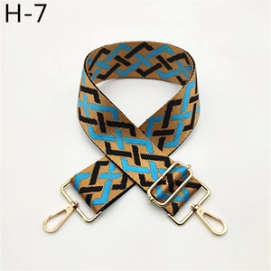 Detail view of adjustable geometric woven bag strap with golden metal swivel hooks