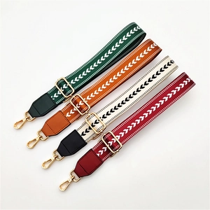 Detail of bohemian arrow-woven purse straps with gold hooks in green, orange, white, and red