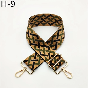 Macro detail of tricolor geometric woven strap with golden metal swivel hooks
